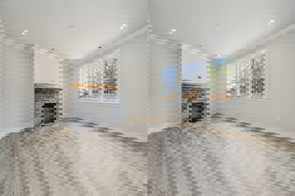 A room with a fireplace and a wood floor.