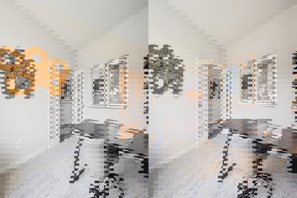 A room with a desk and chairs.