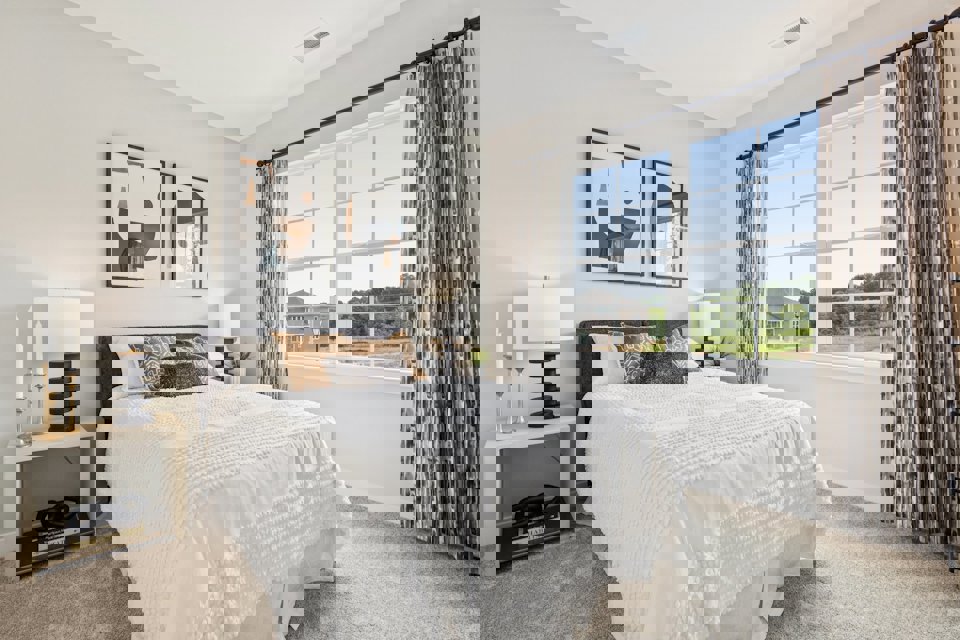 A bedroom with a large window.