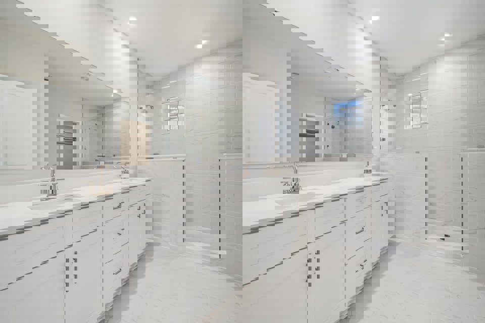 A bathroom with white cabinets.