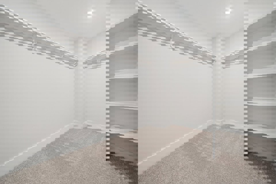 A white room with a white shelf.
