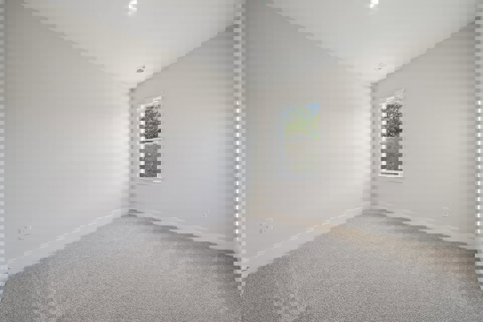 A room with a window and carpet.