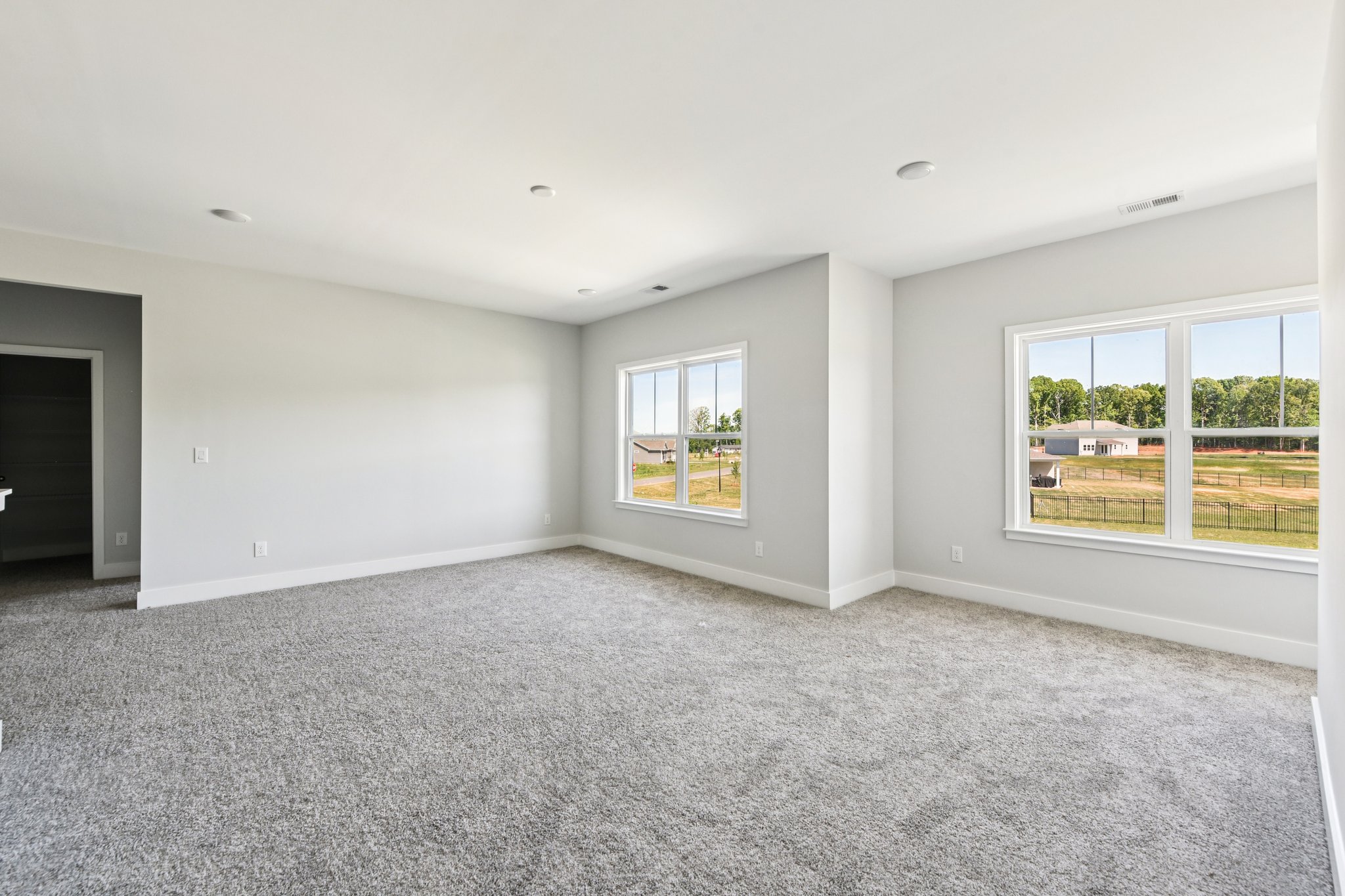 A room with windows and a carpet.