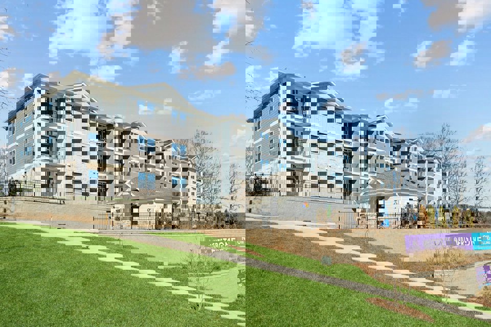 A large white building with a lawn in front of it.