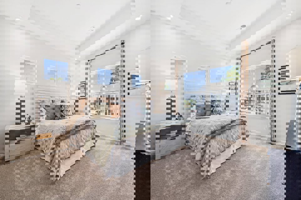 A bedroom with a large window.