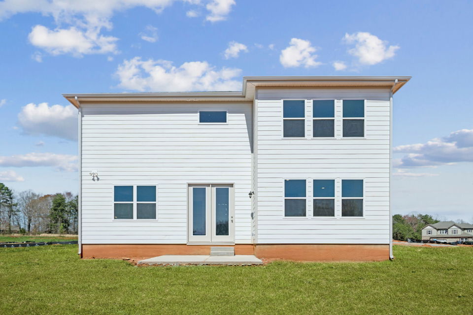 A white house with a grass yard.