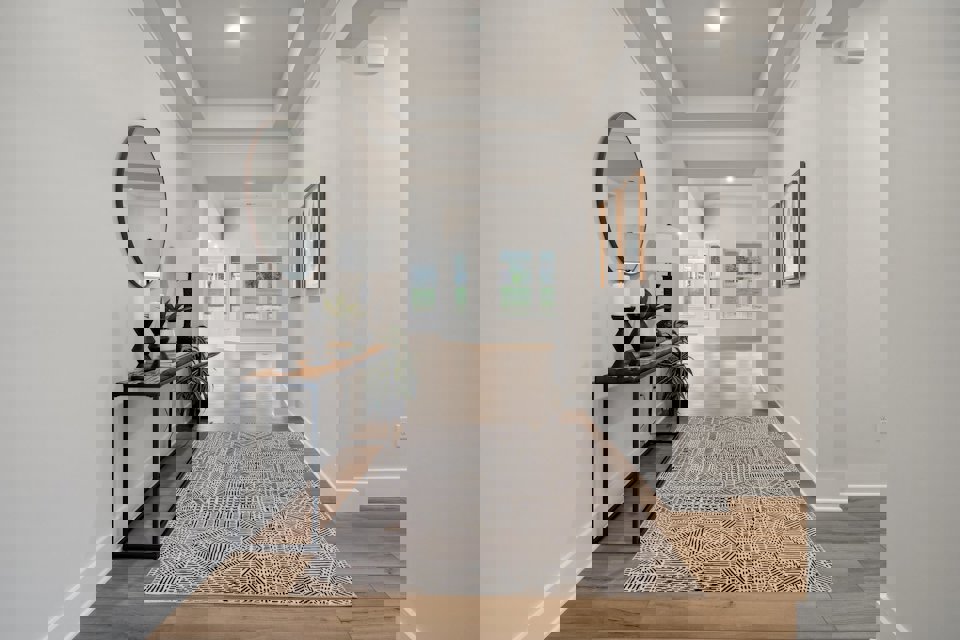 A room with a rug and a mirror.