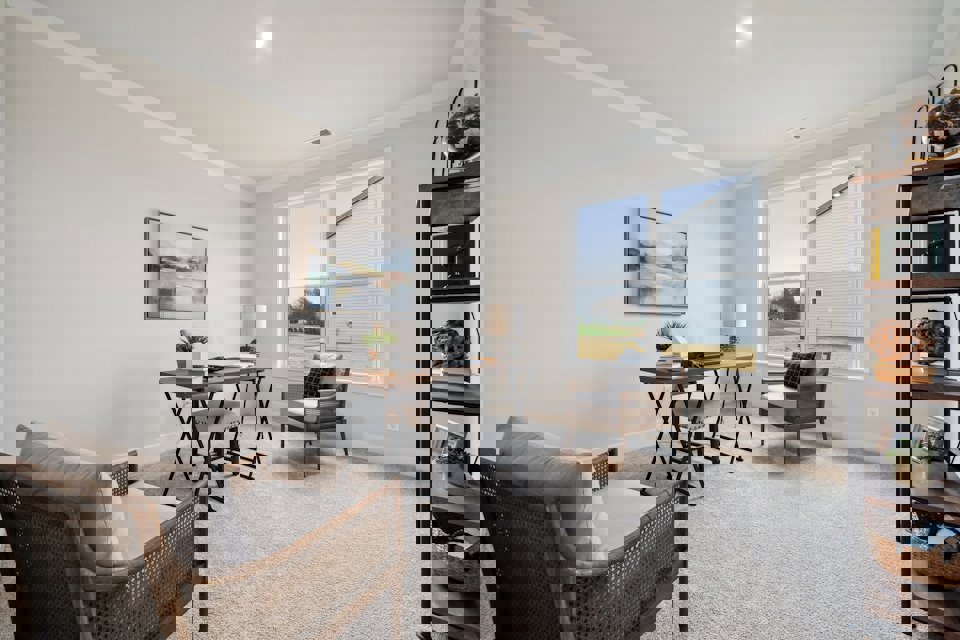 A living room with a table and chairs.