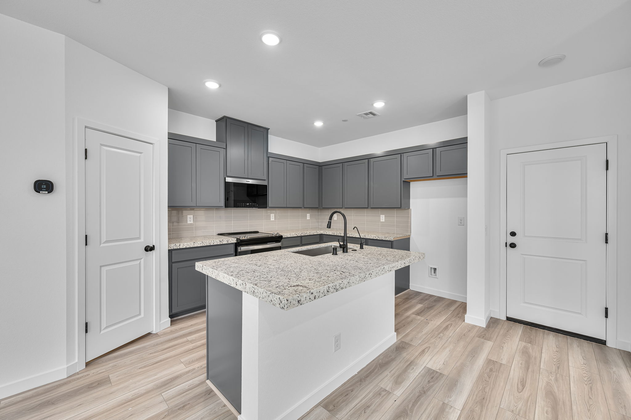 A kitchen with black cabinets.