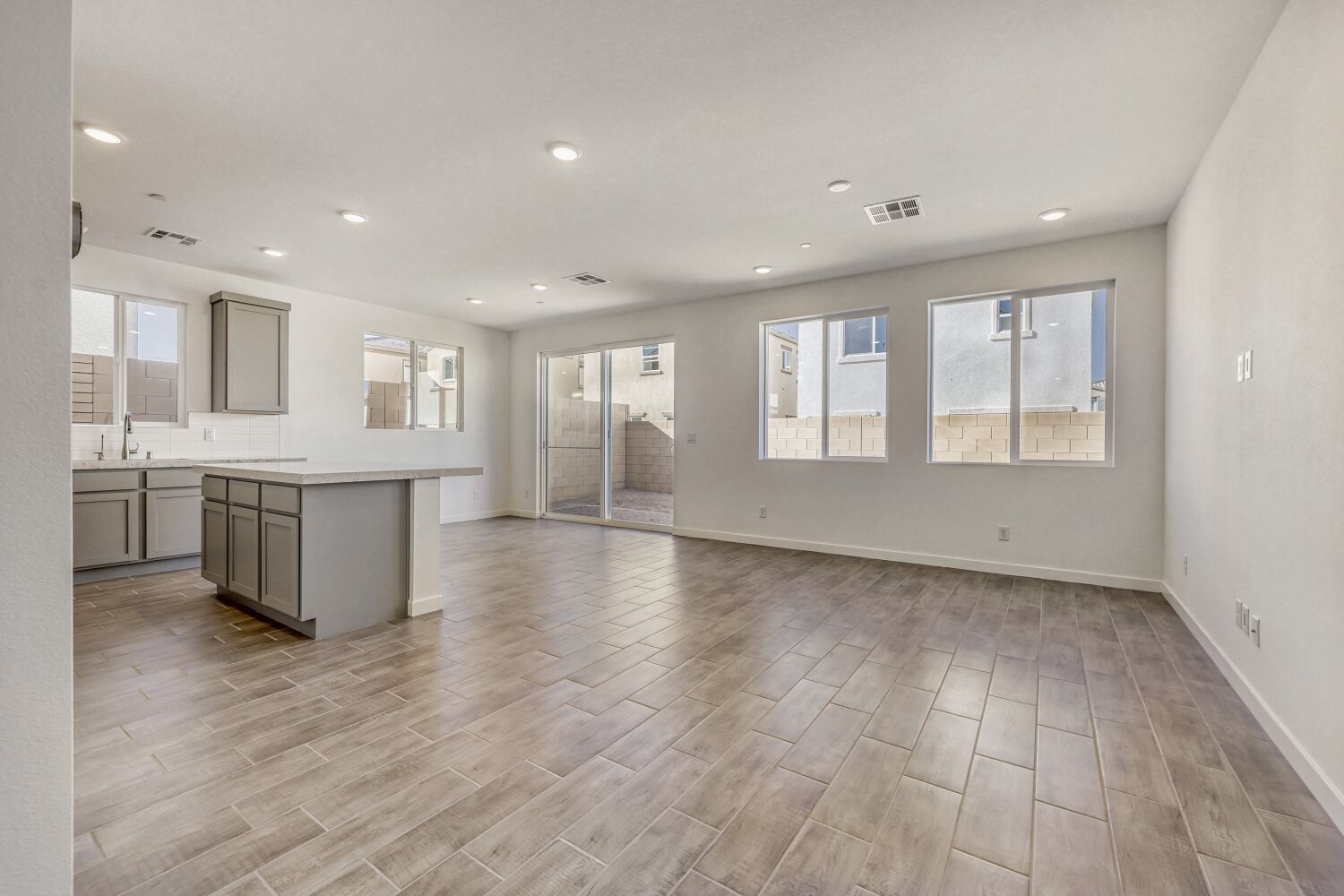 A large empty room with a wood floor and white walls.