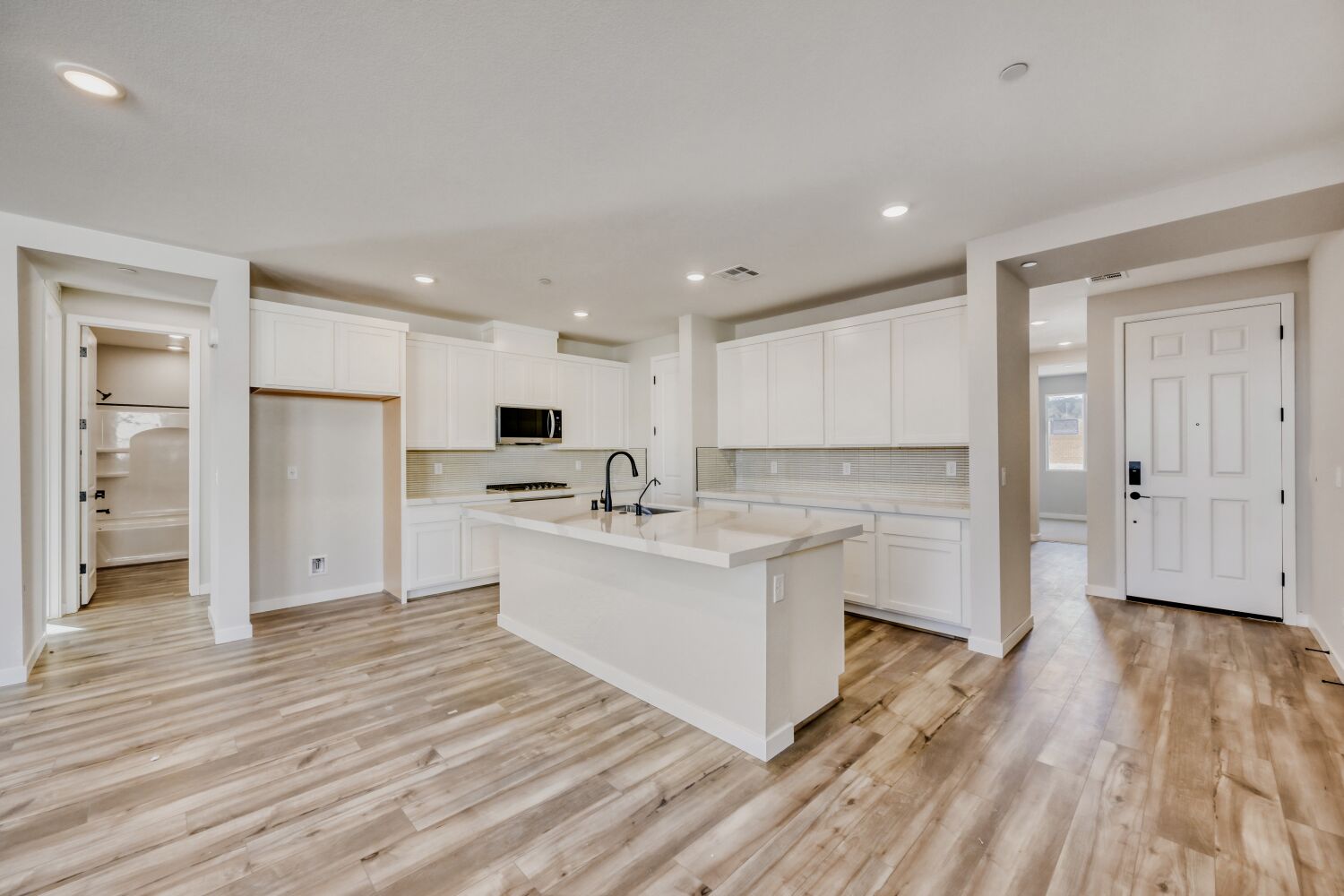 A kitchen with white cabinets.