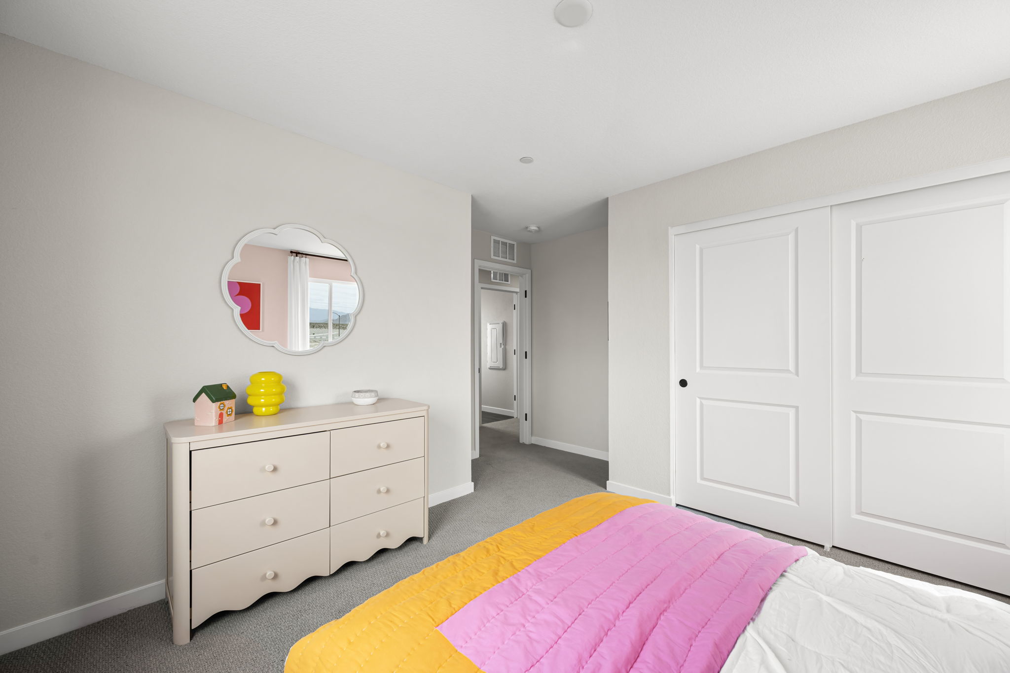A bedroom with white cabinets.