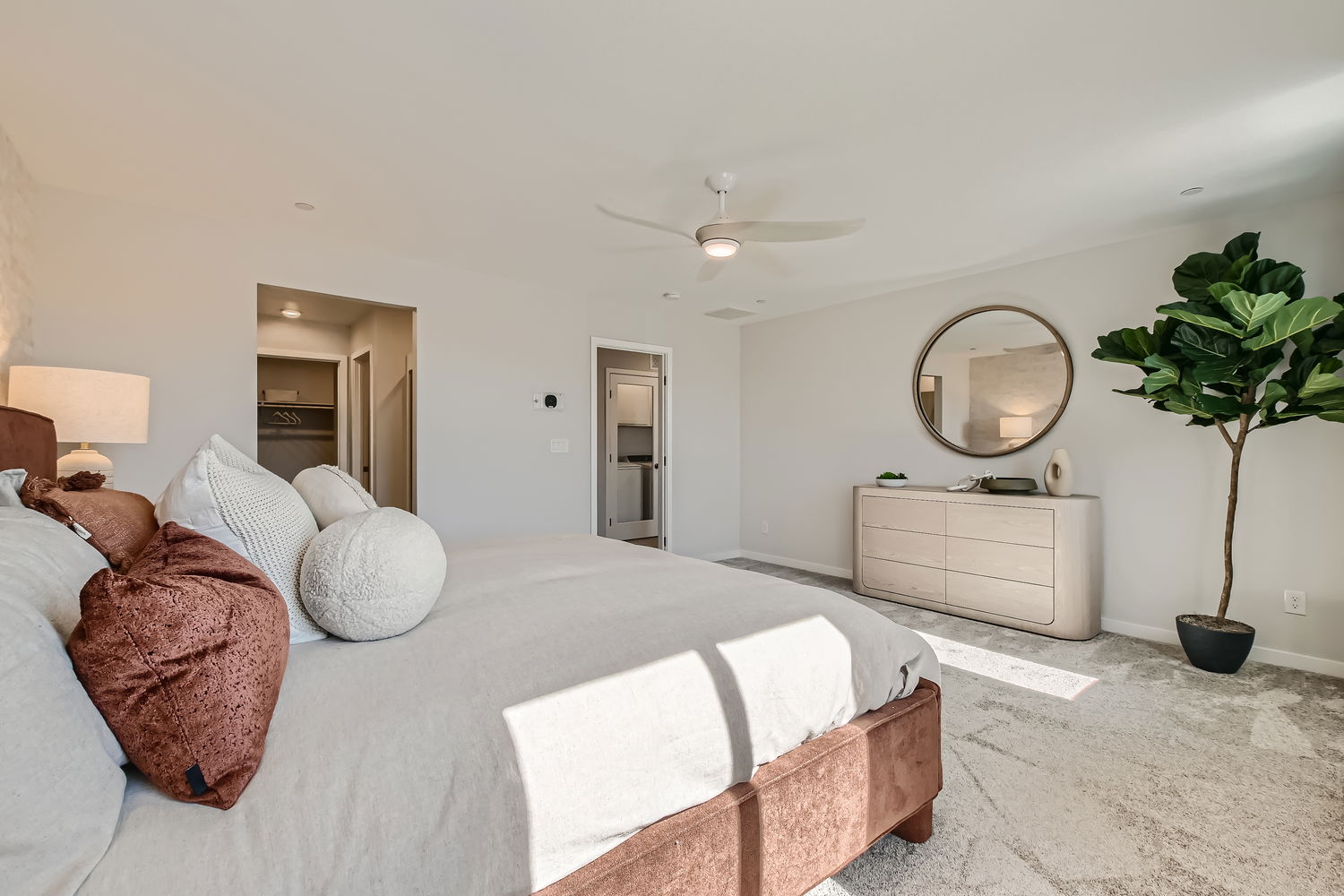 A bedroom with a bed and a plant.