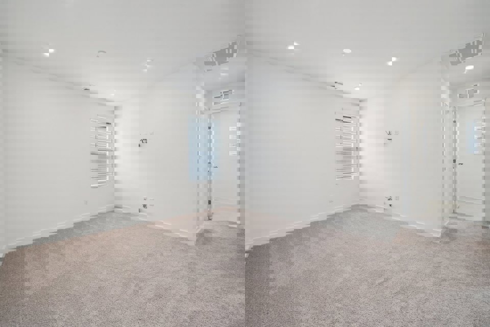 A room with a carpet and a door.