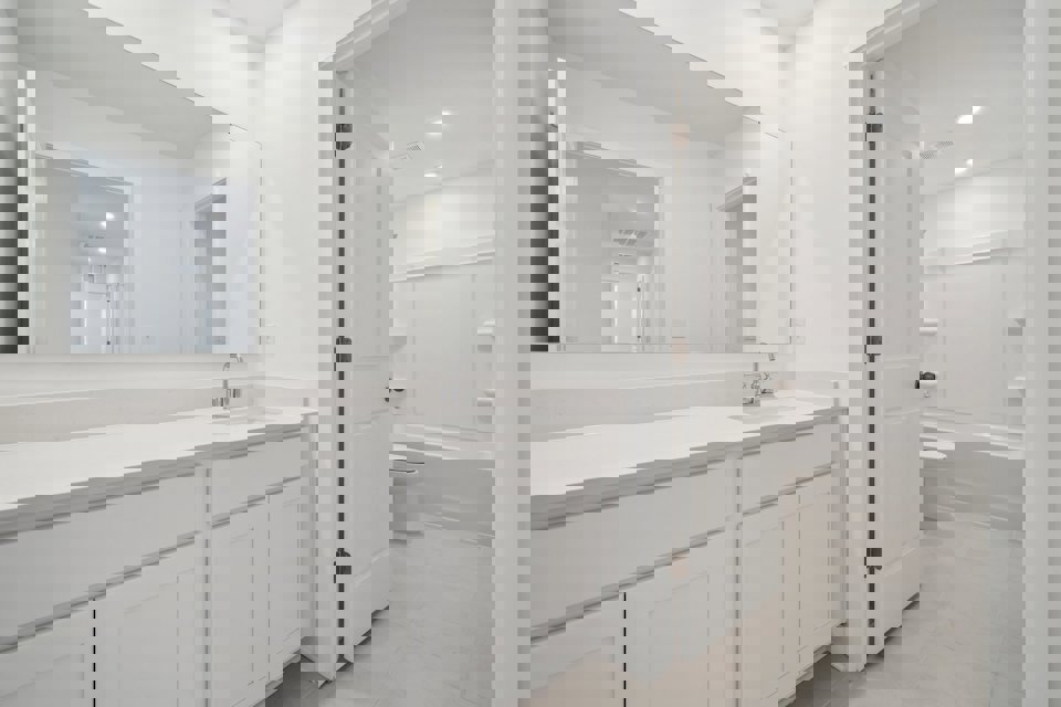 A bathroom with white cabinets.