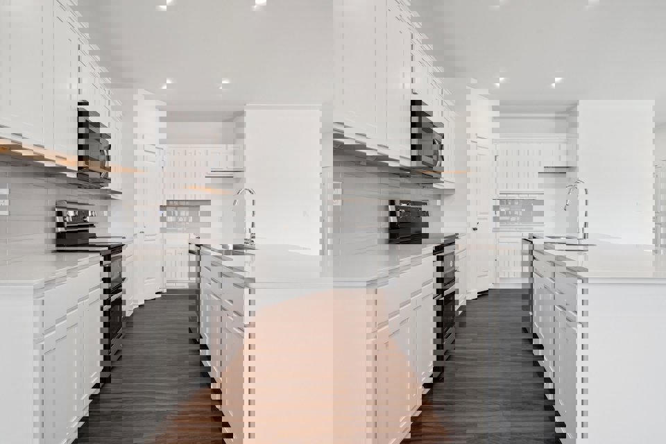 A kitchen with white cabinets.