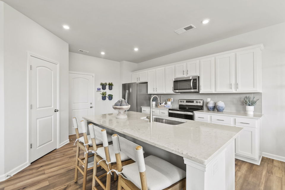 A kitchen with white cabinets.
