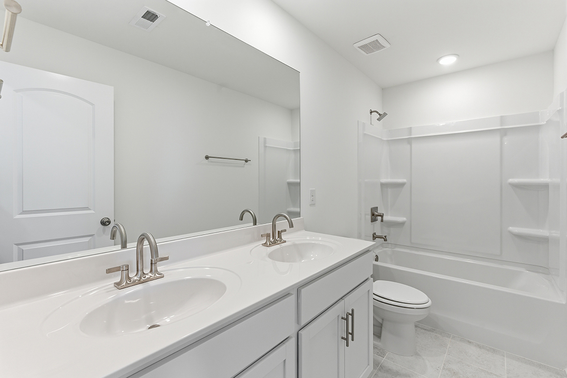 A bathroom with a tub sink and toilet.