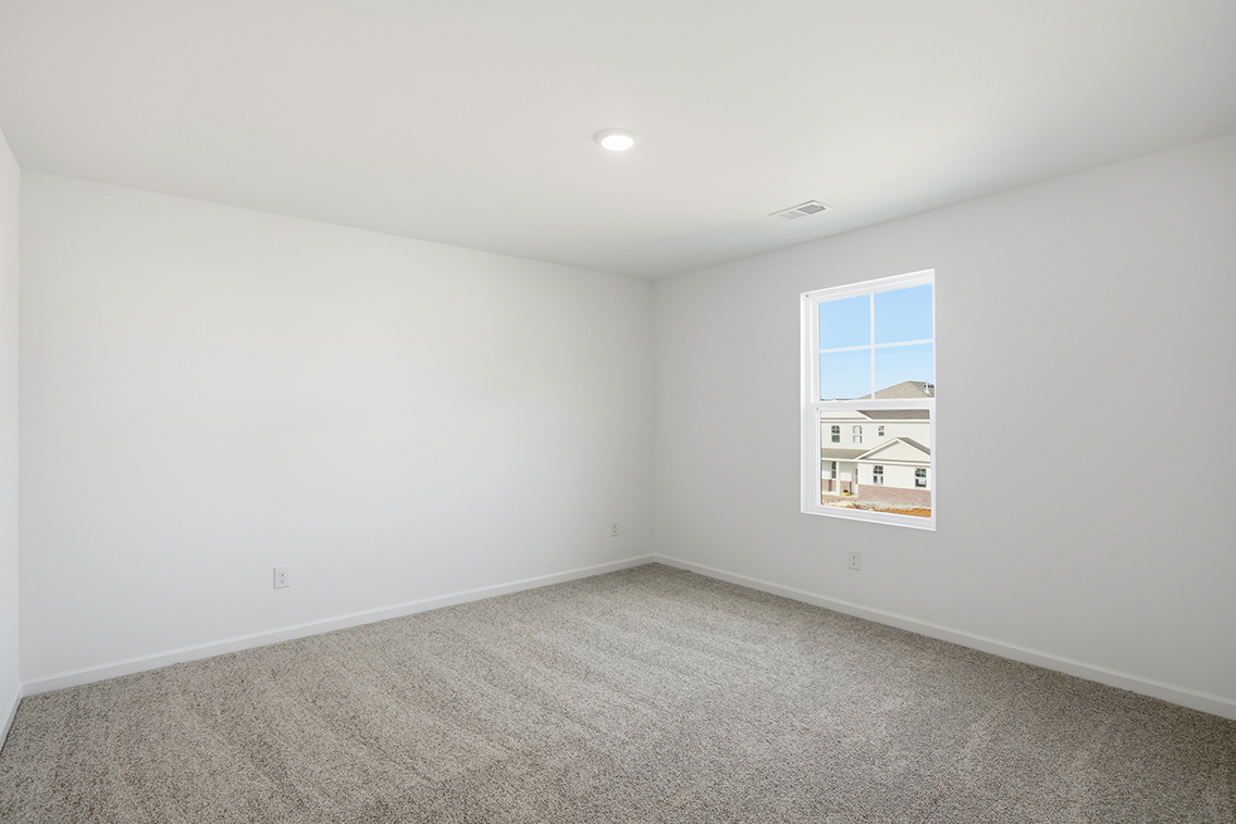 A room with a window and a carpet.