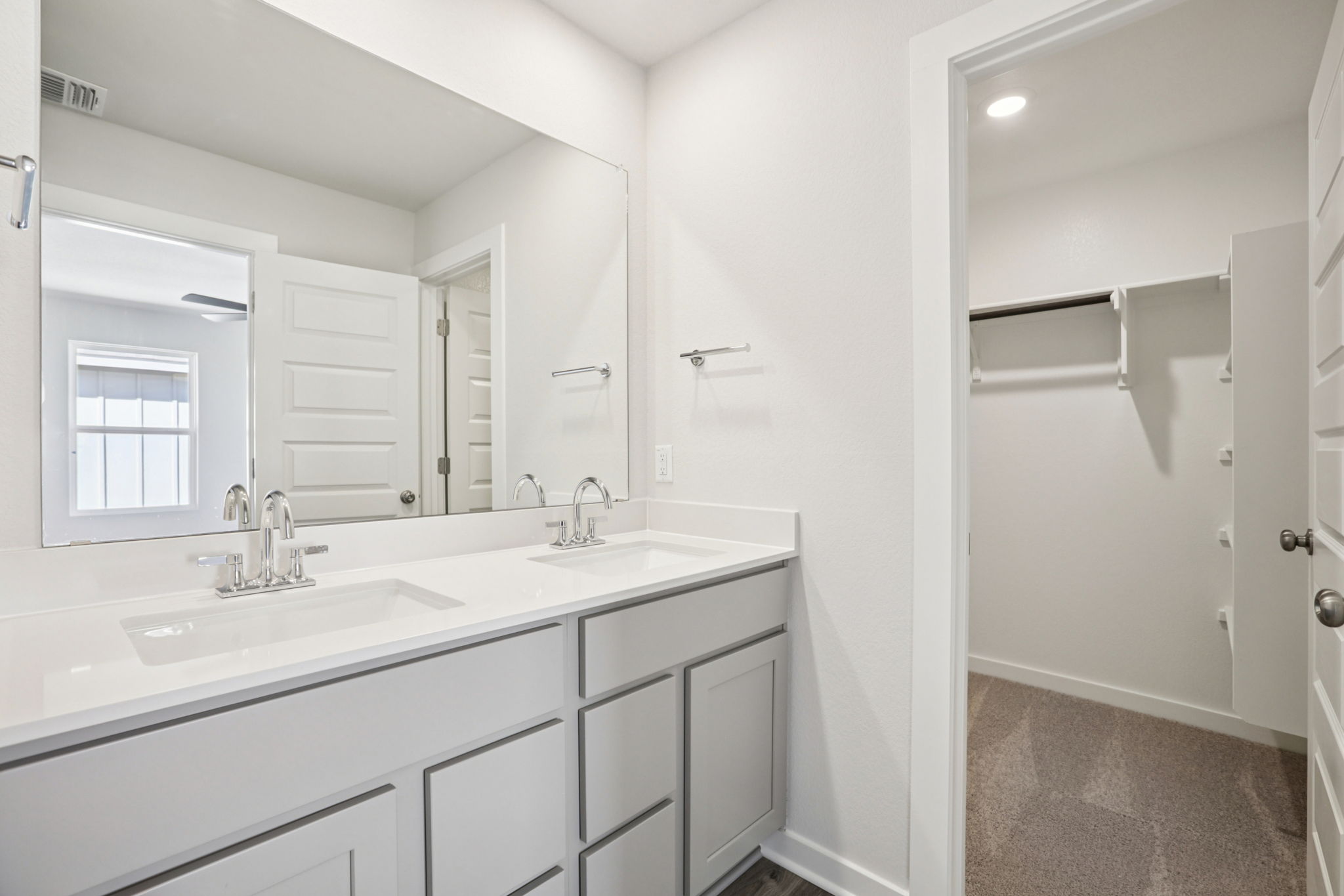 A bathroom with white cabinets.