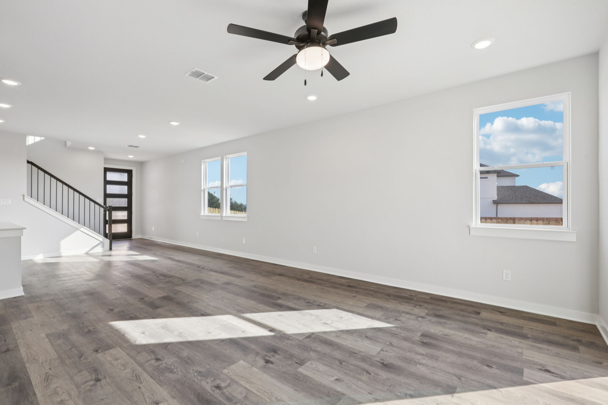A room with a wood floor and a ceiling fan.
