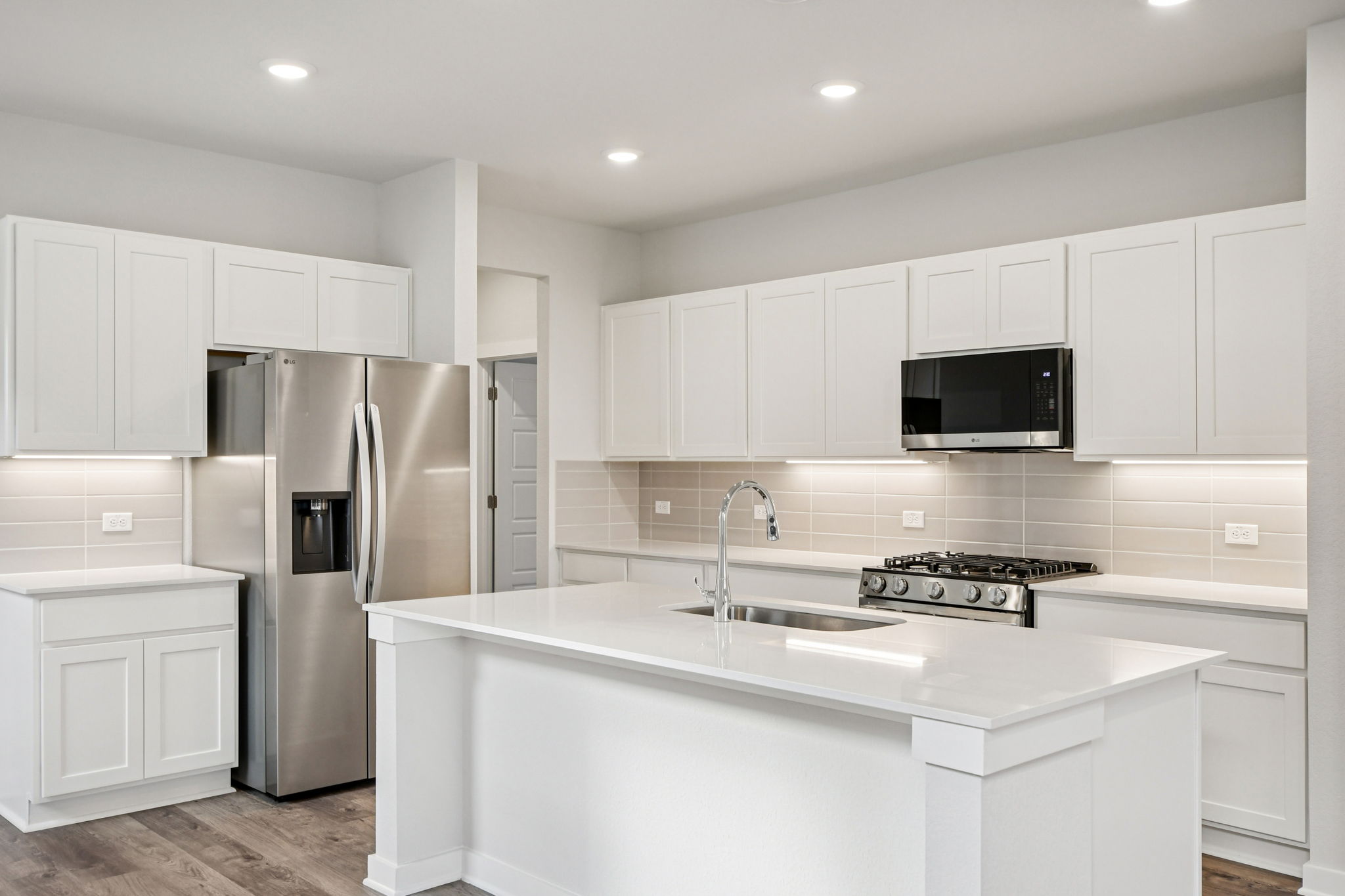 A kitchen with white cabinets.