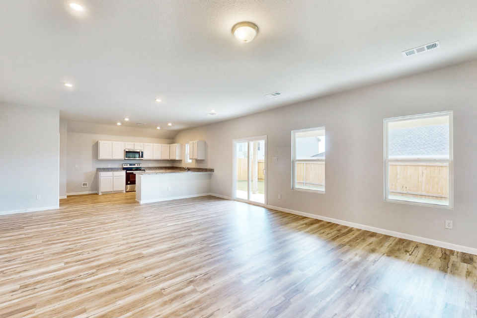 A large empty room with a wood floor and white walls.