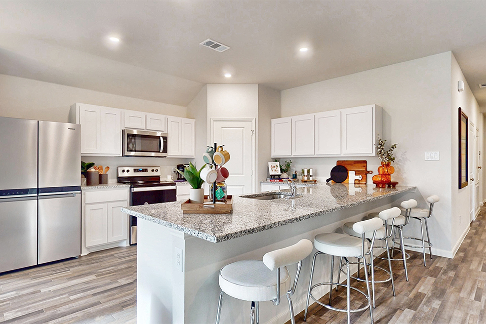 A kitchen with white cabinets.