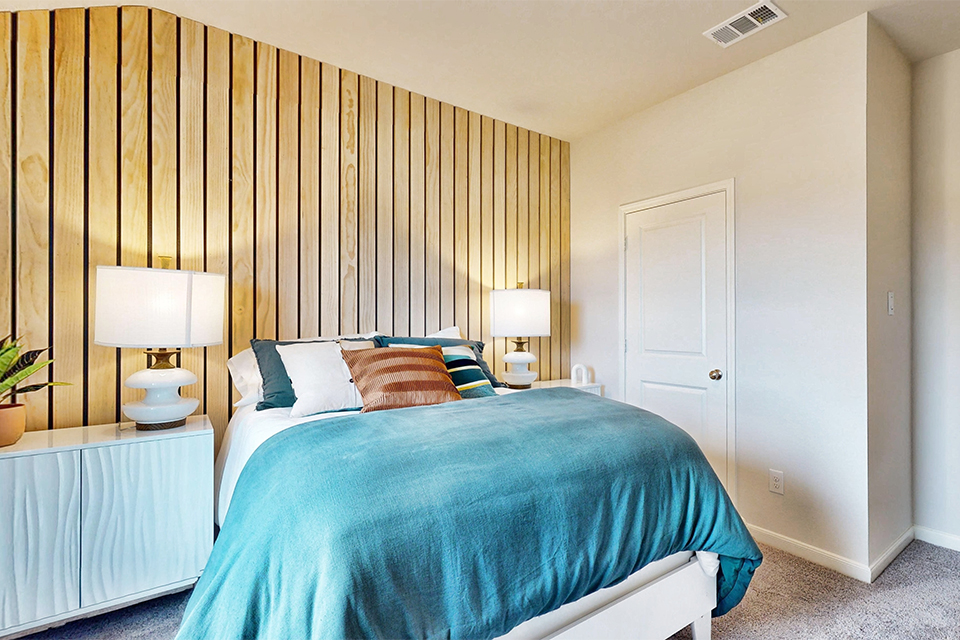 A bed with a blue comforter.