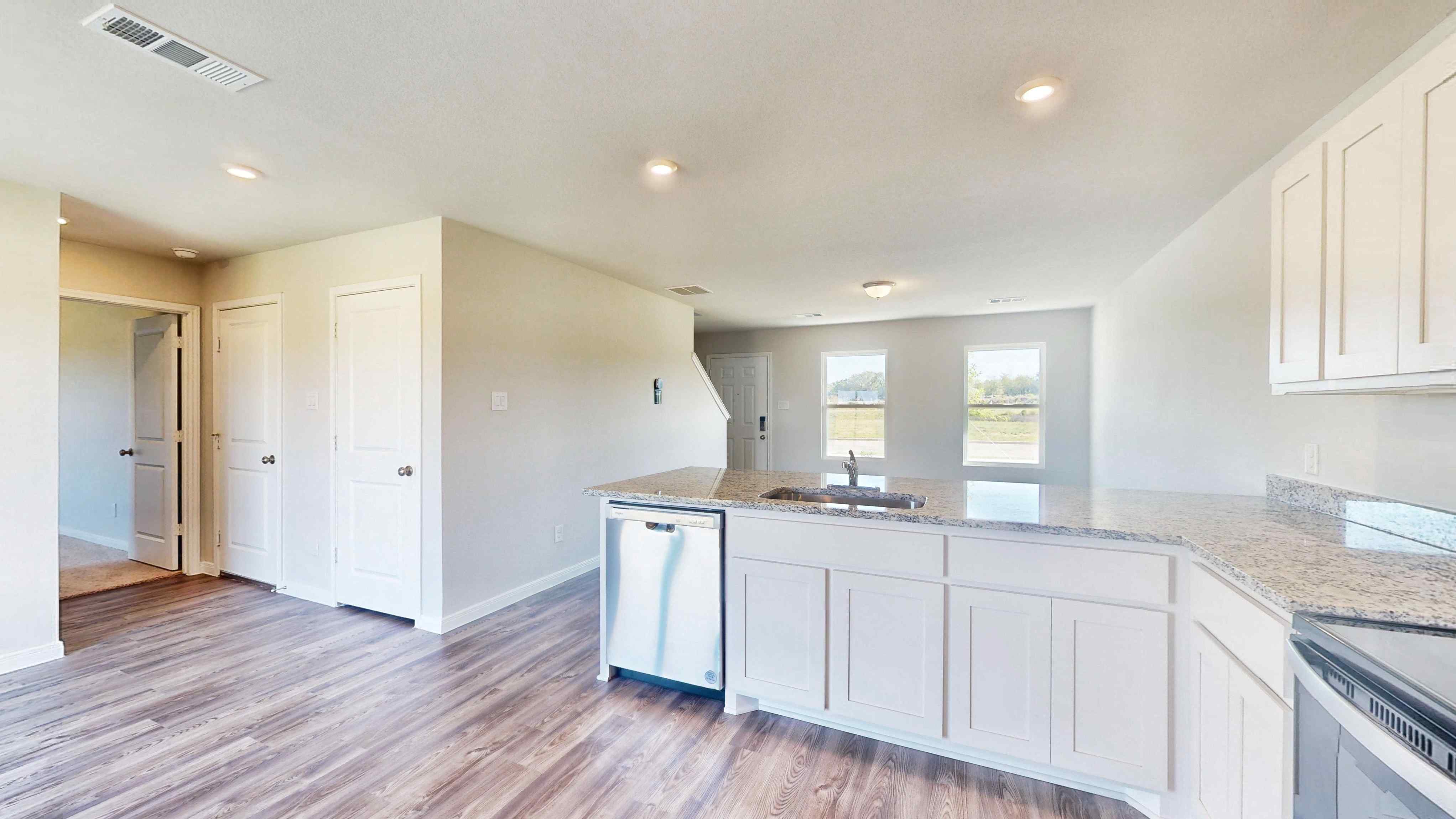 A kitchen with white cabinets.