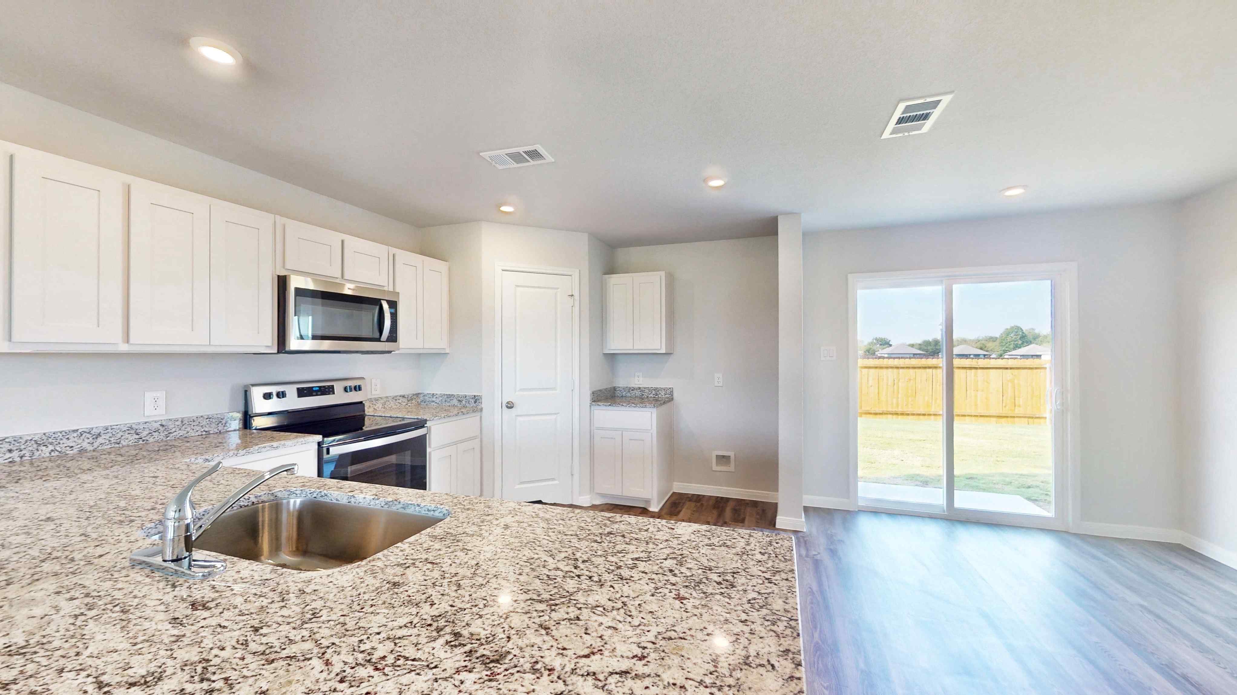 A kitchen with white cabinets.