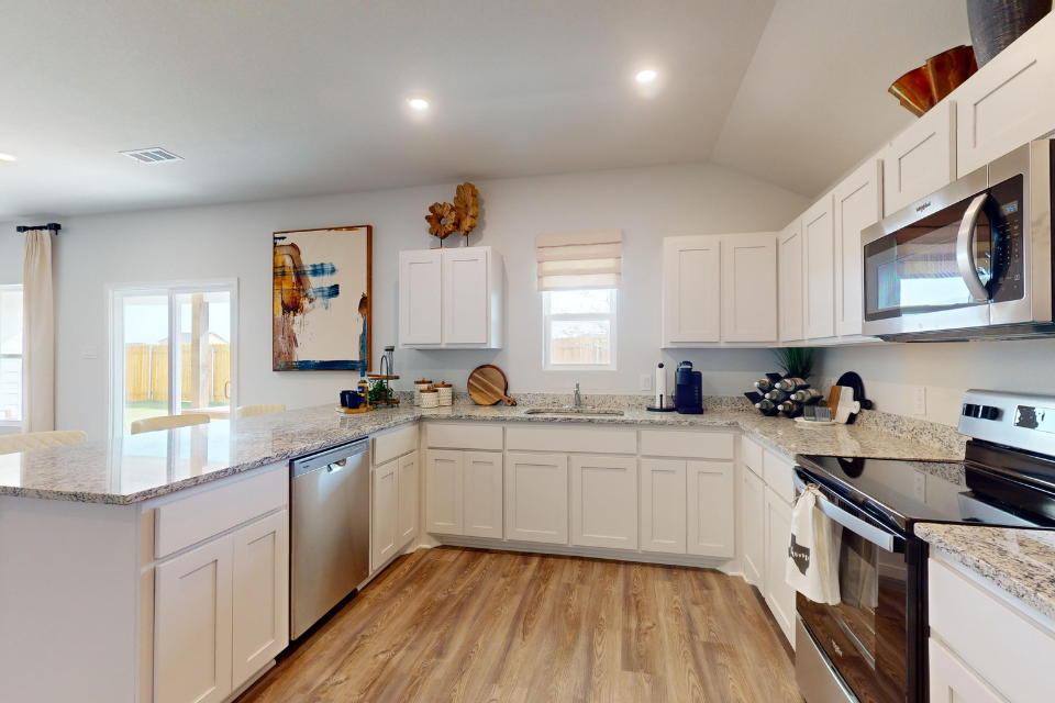 A kitchen with white cabinets.
