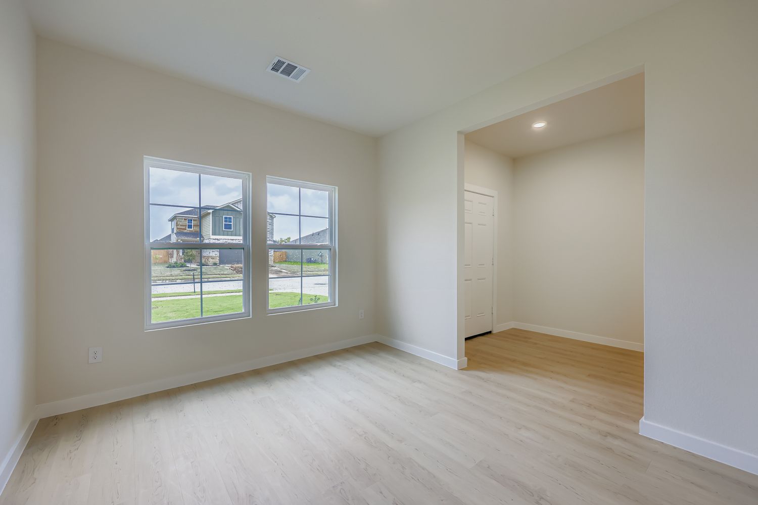 A room with a wood floor and a window.