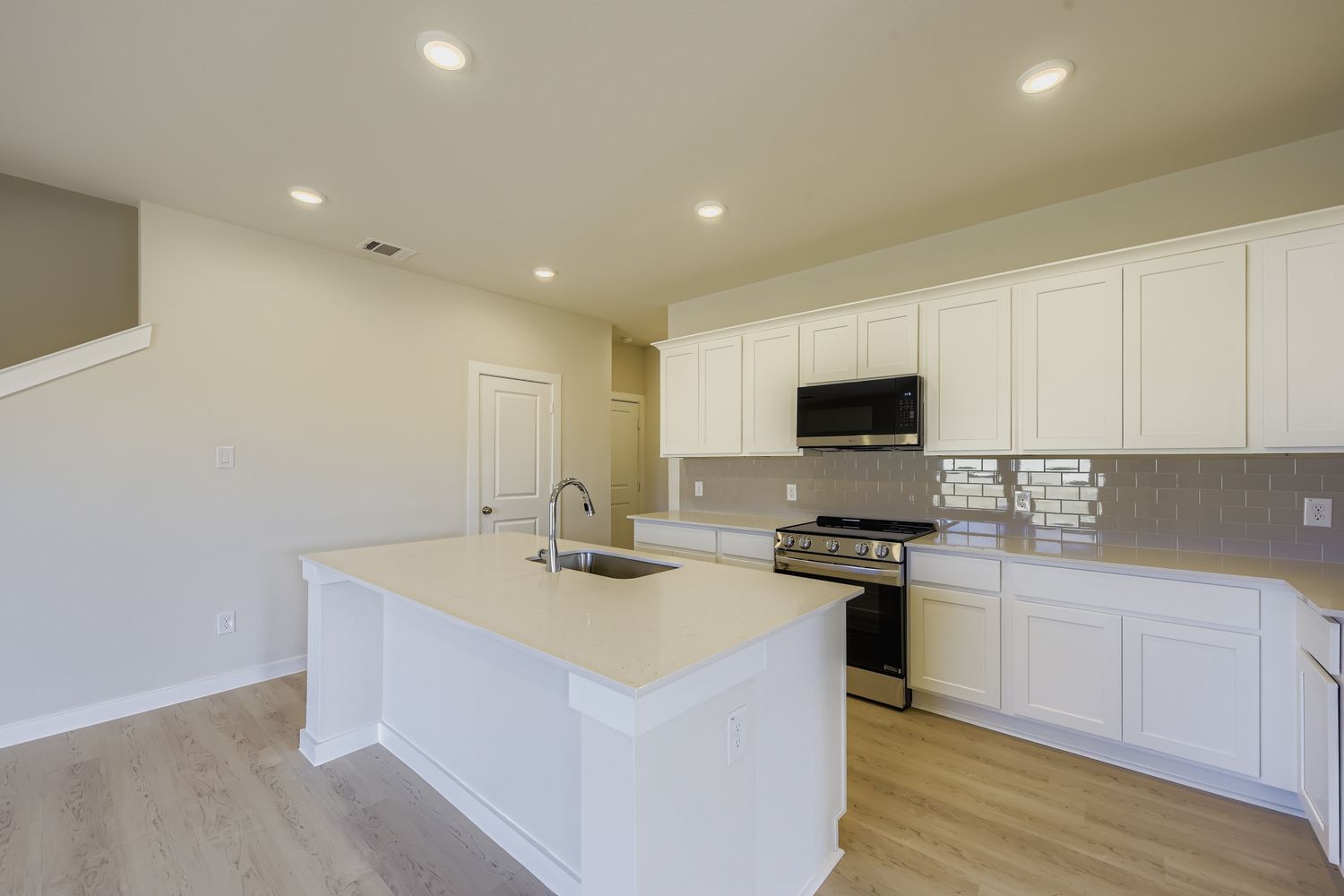A kitchen with white cabinets.