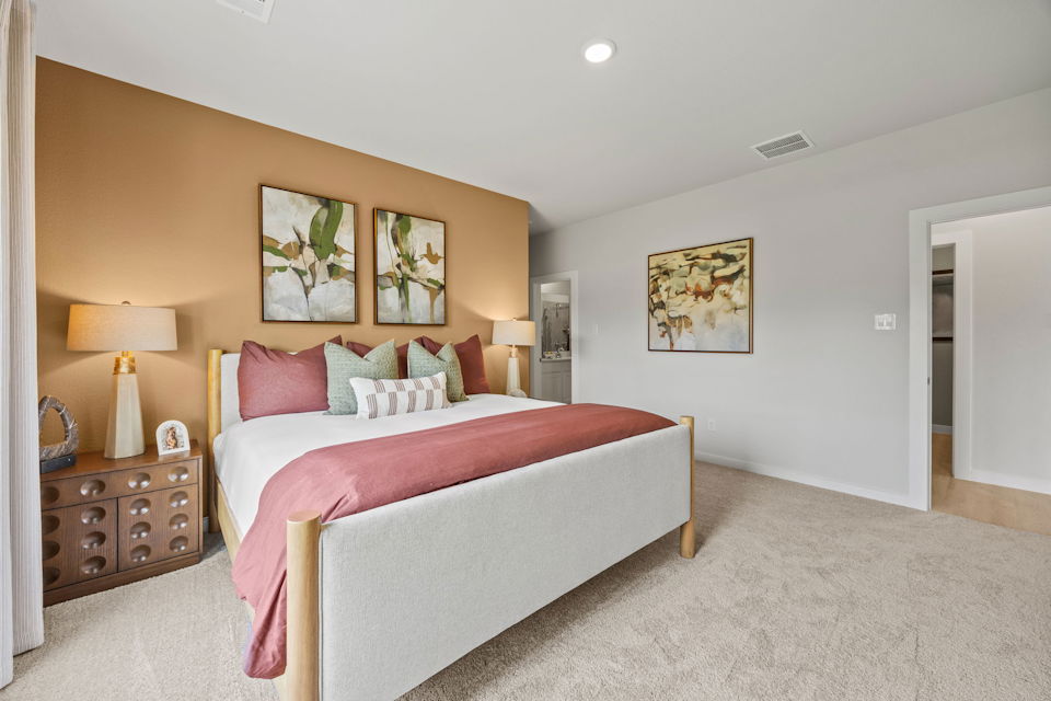 A bedroom with a bed and lamps.