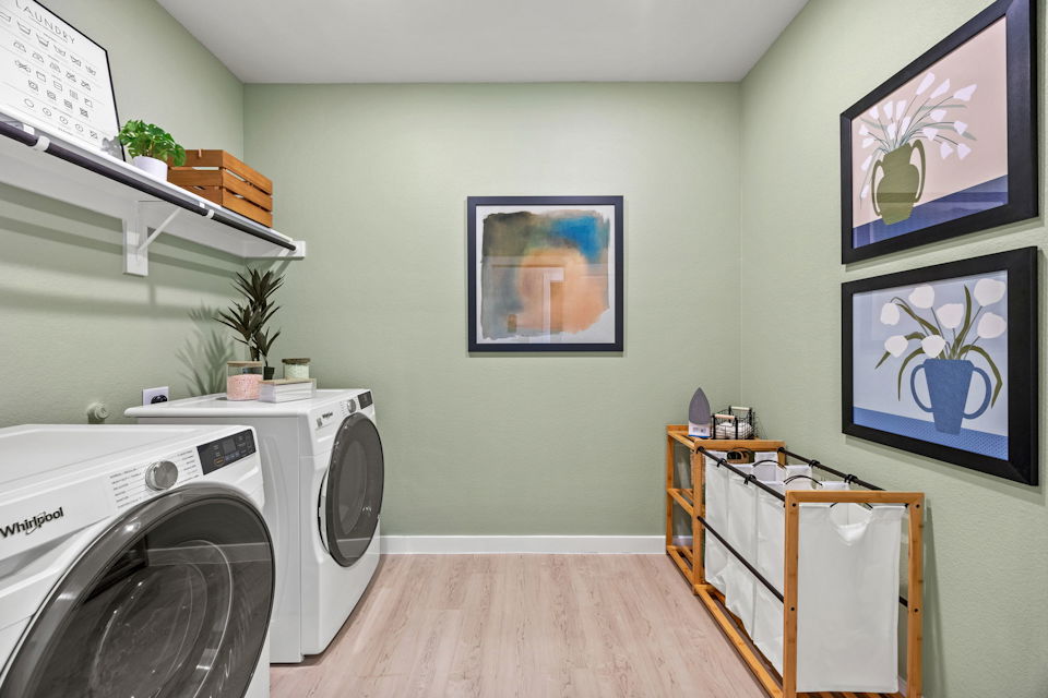 A room with a washing machine and a table.