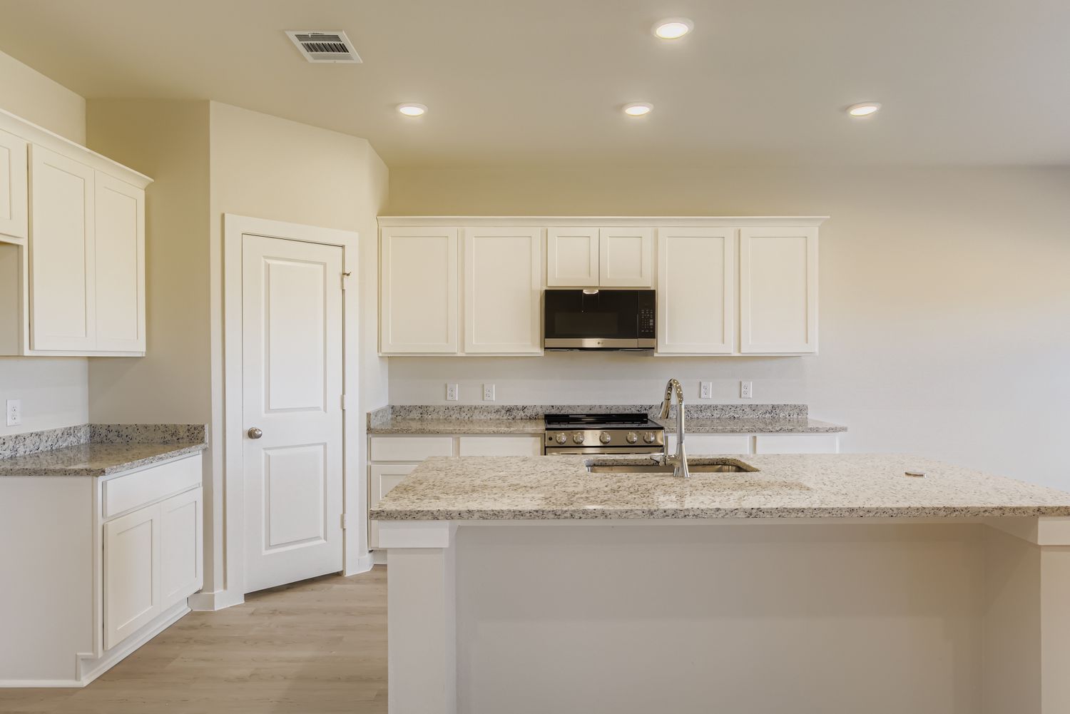A kitchen with white cabinets.