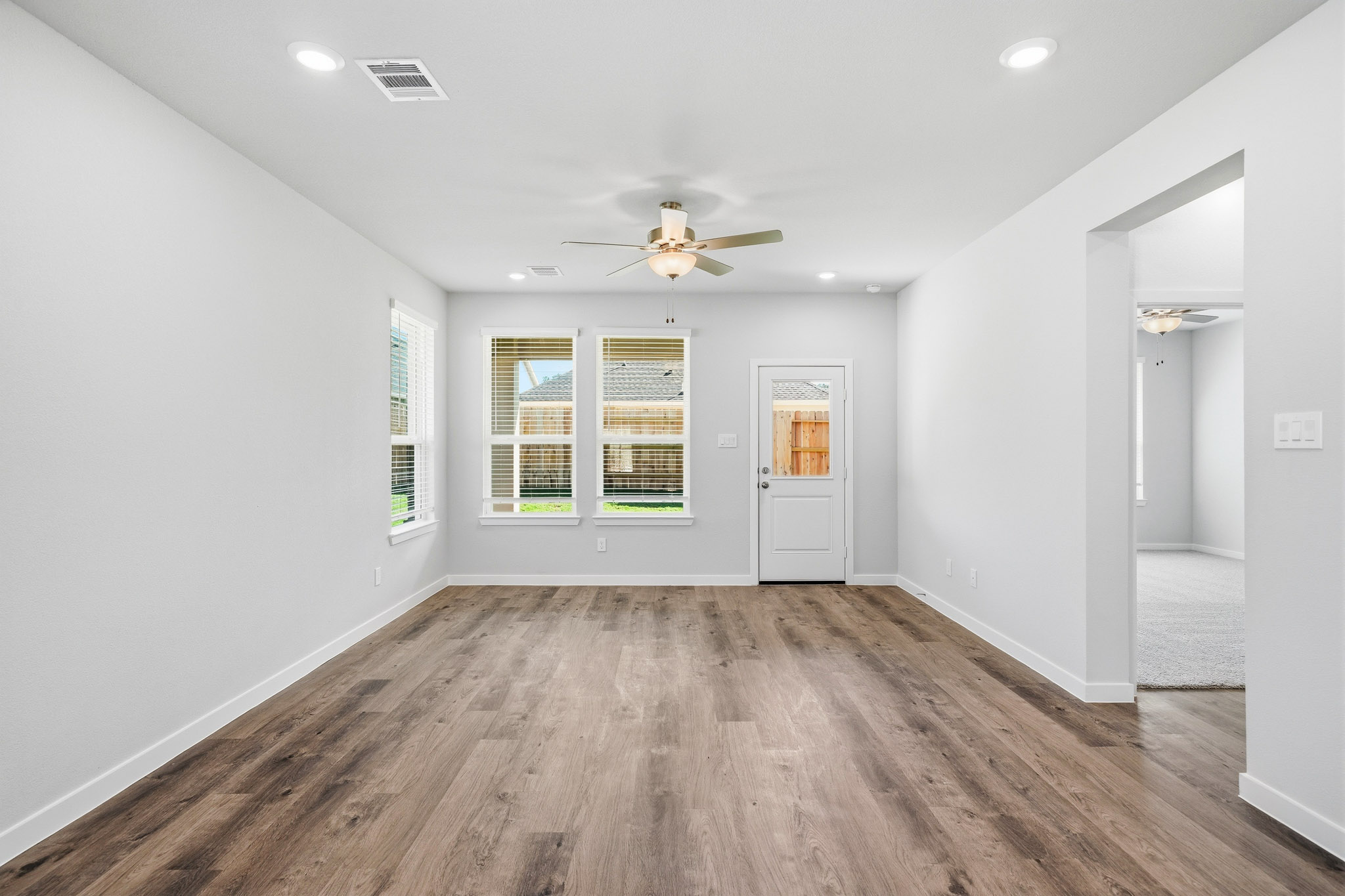 A room with a wood floor and a ceiling fan.