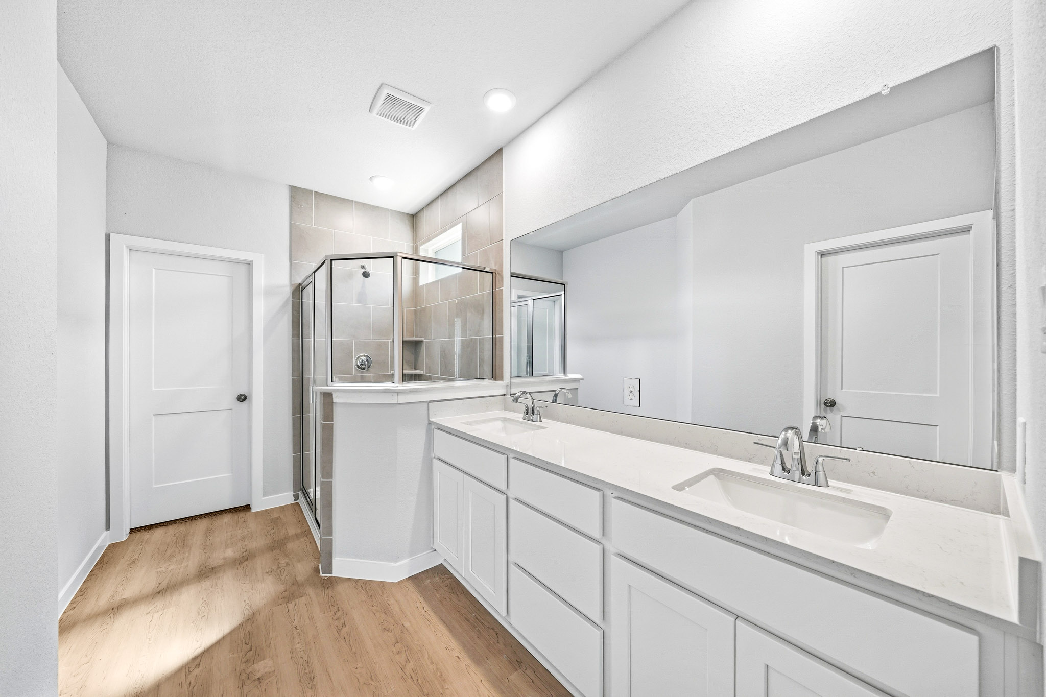 A bathroom with white cabinets.