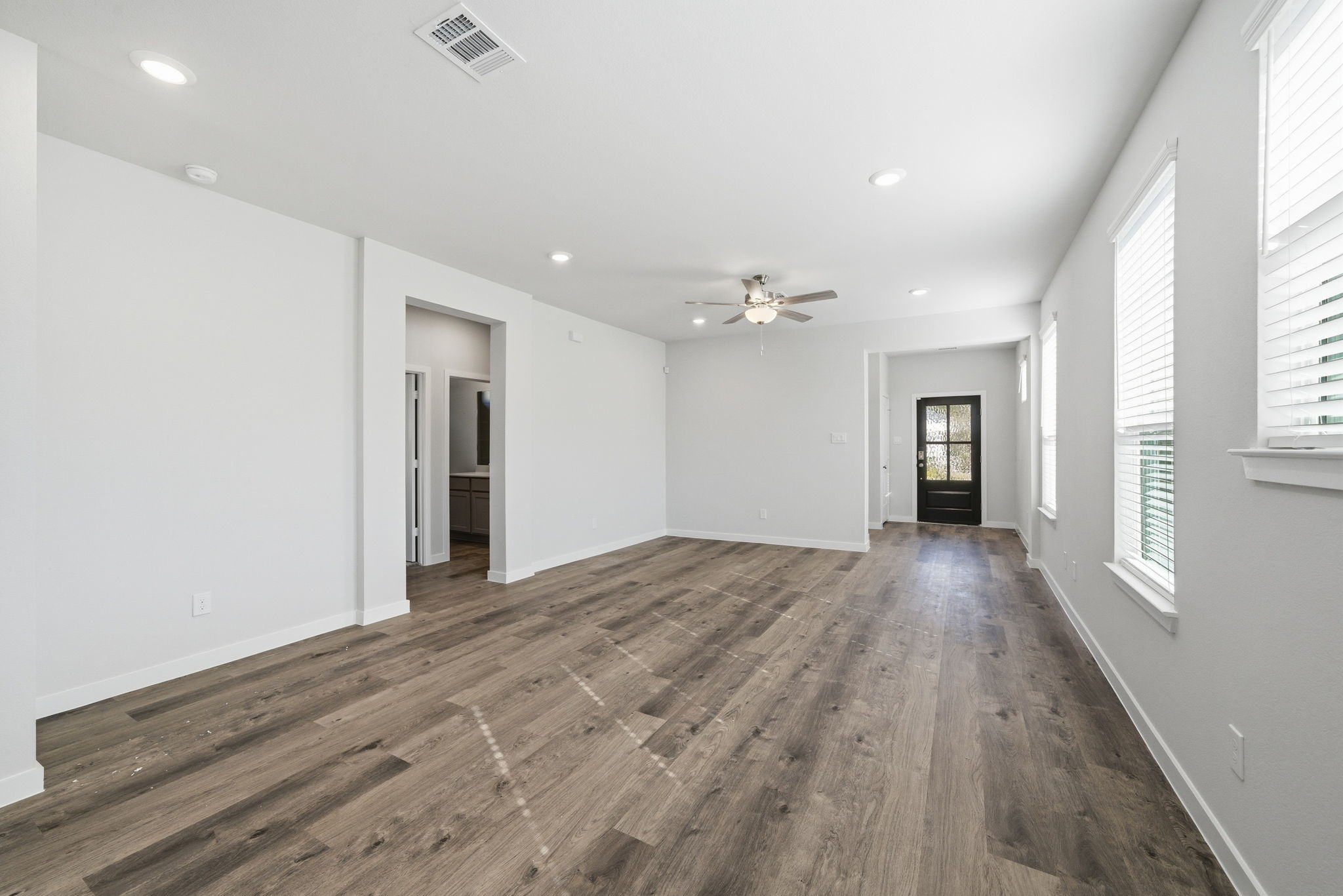 A room with a wood floor and a ceiling fan.