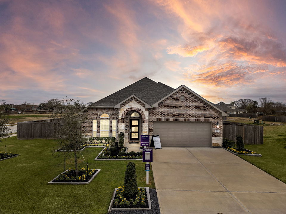 A building with a driveway and a sunset in the background.