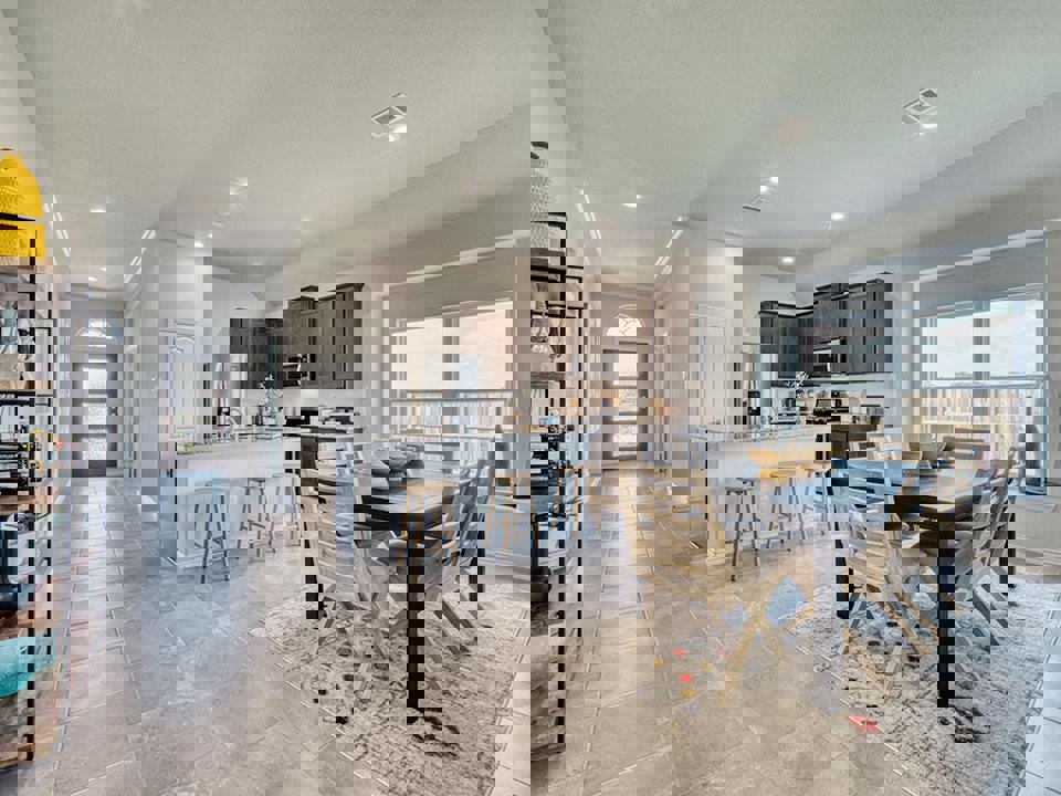 A kitchen with a dining table and chairs.