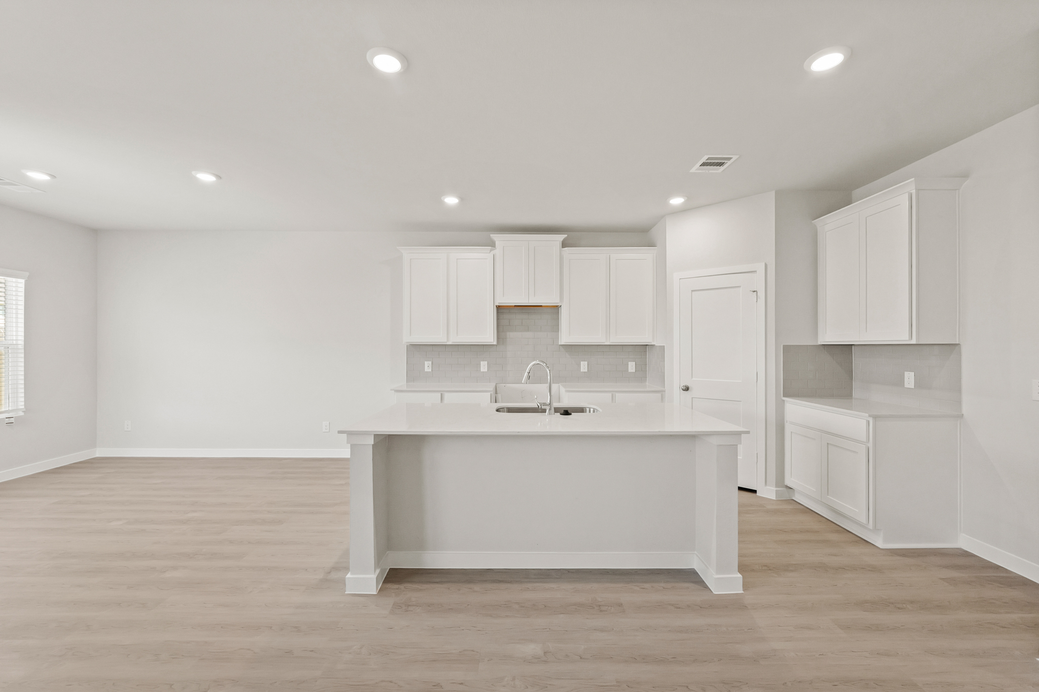 A large white kitchen with white cabinets.