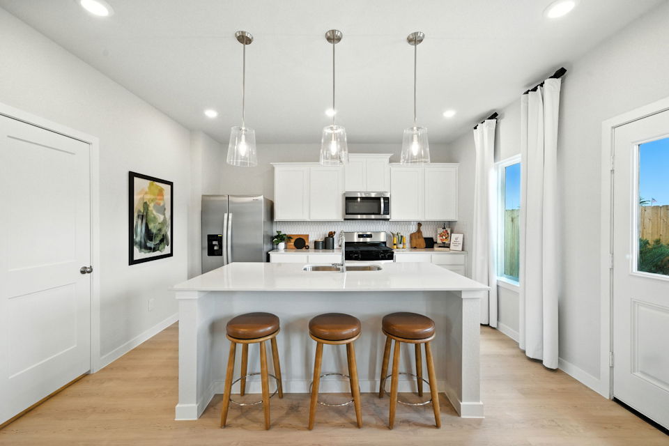 A kitchen with a bar stool and a table.
