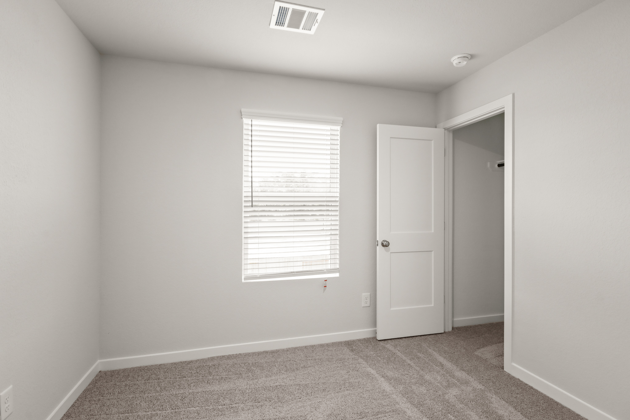 A room with white walls and a door with a window.
