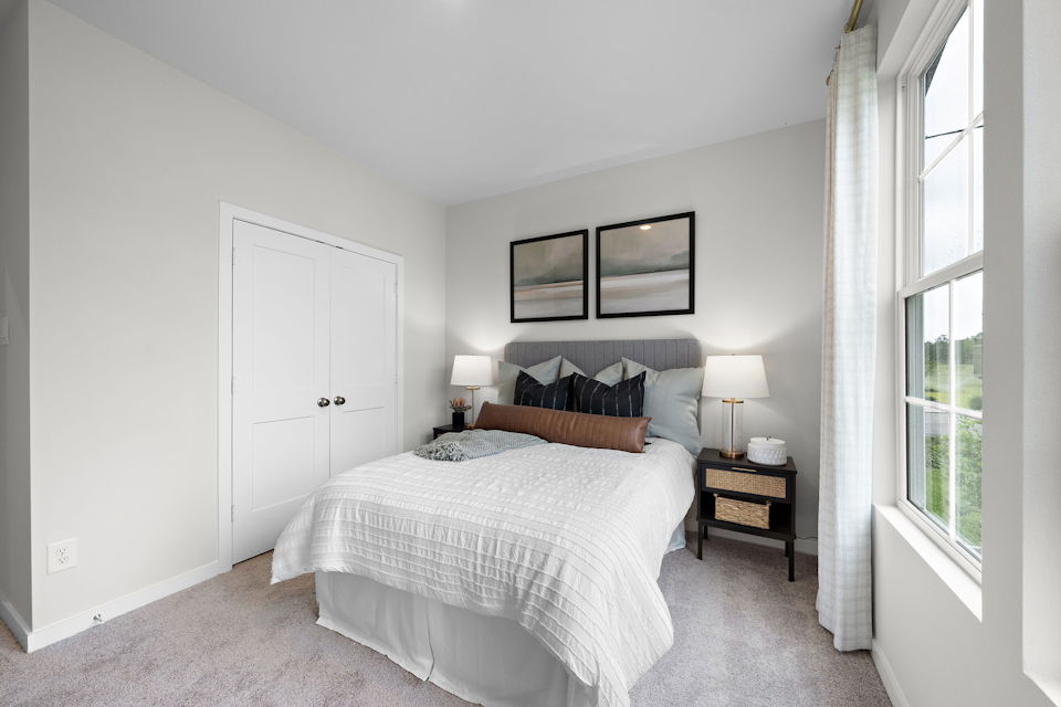 A bedroom with a bed and lamps.