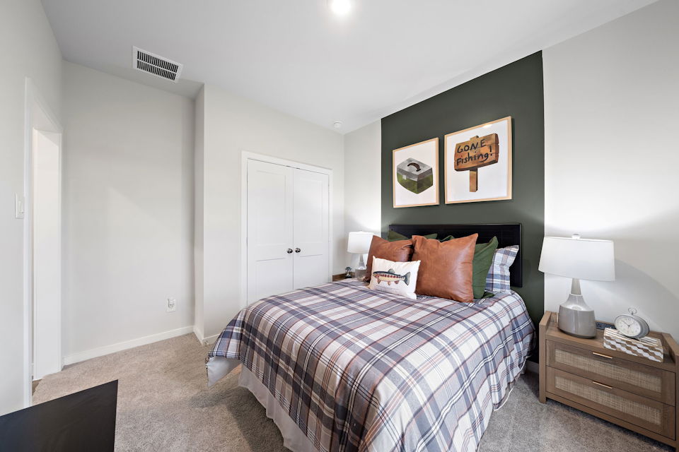 A bedroom with a bed and a dresser.