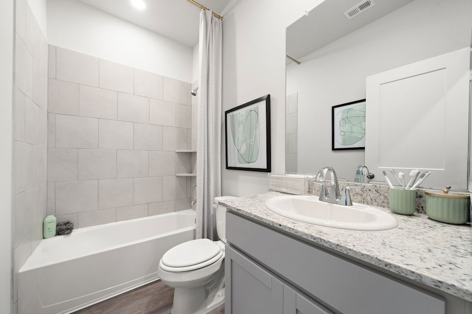 A bathroom with a tub sink and toilet.