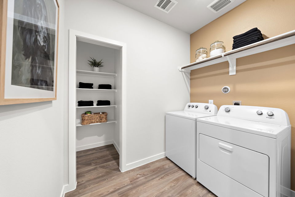 A white room with a shelf and a white cabinet.