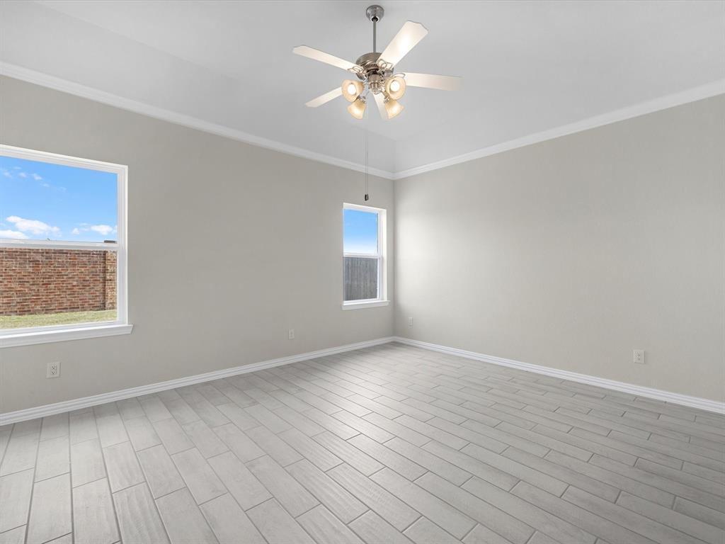 A room with a ceiling fan and a tile floor.